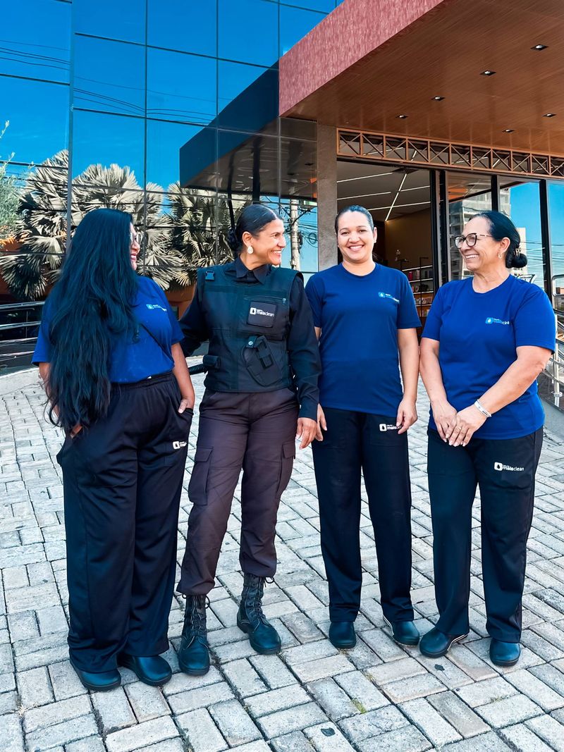 Quatro colaboradoras do Grupo Mais Clean em frente a um prédio comercial