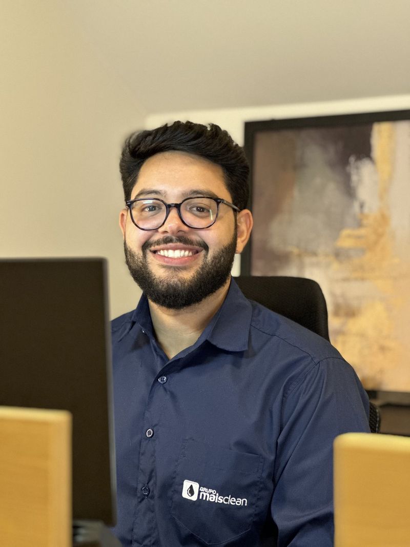 Colaborador do administrativo sorrindo na sua mesa