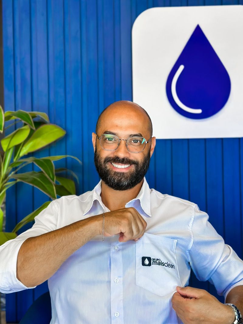 Gestor do Grupo Mais Clean mostrando o bordado da camisa