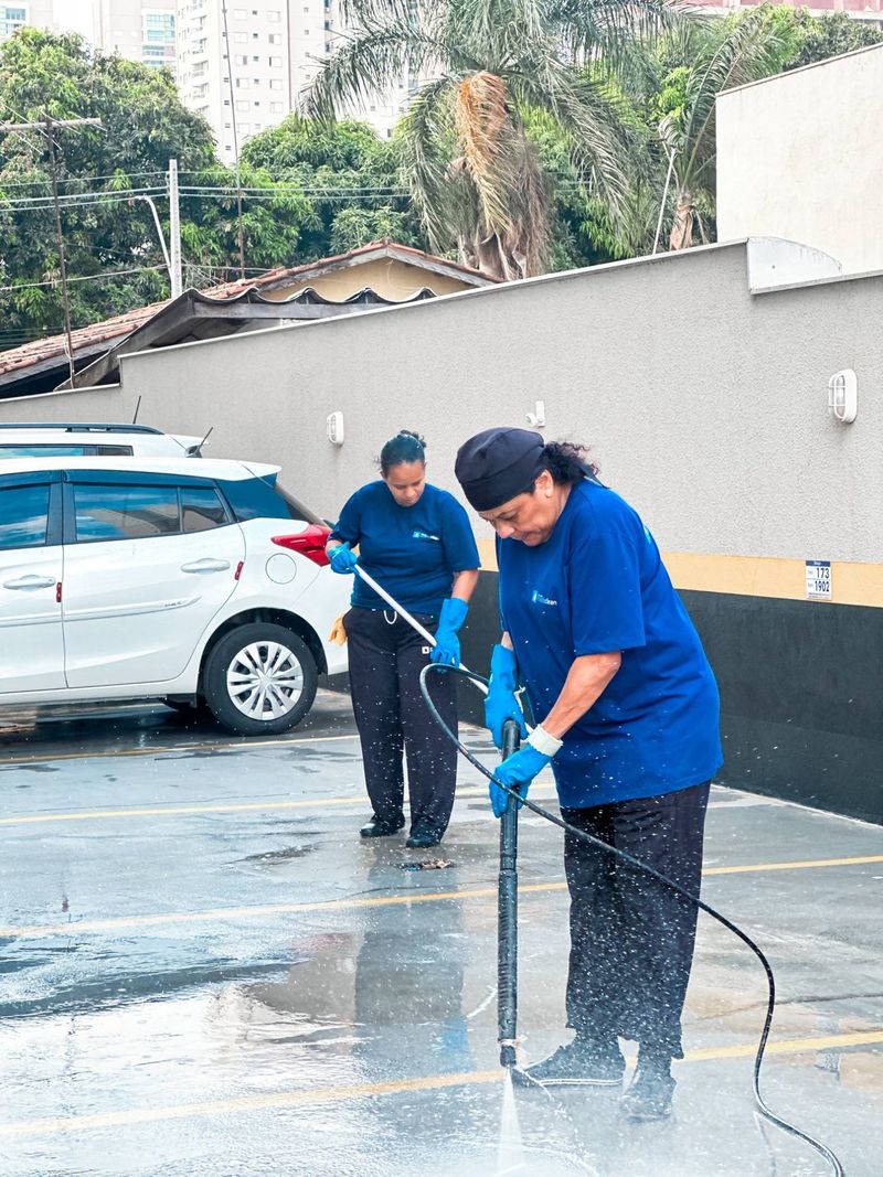 Duas colaboradoras lavando a garagem de um condomínio